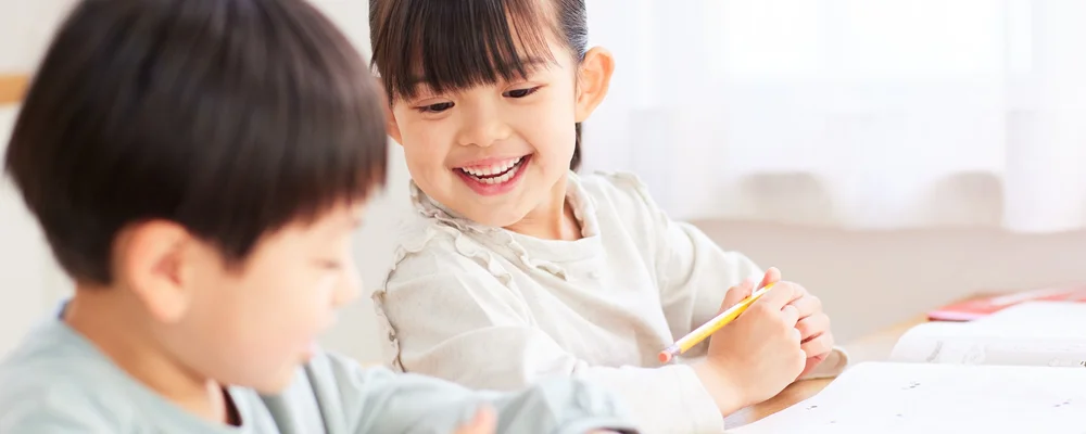 机に向かって笑顔を見せる子どもの成長のひとこま｜獨協大学前シティデンタルクリニック